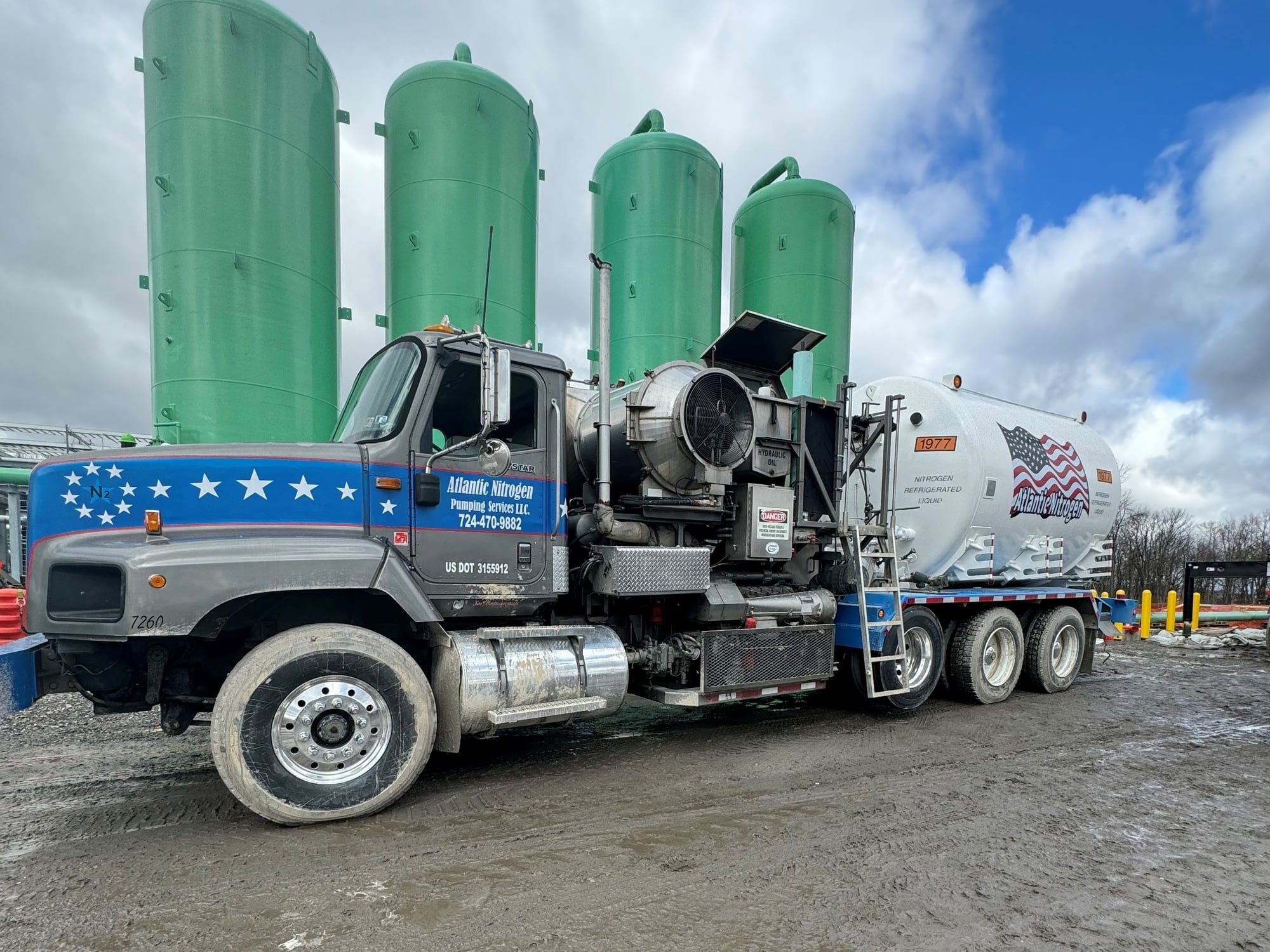 Cryogenic nitrogen pumper unit on a pad with nitrogen storage vessels behind it